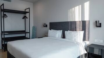 A modern bedroom with a bunk bed, a flat-screen TV, and a bedside table.