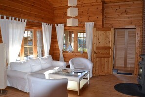 A cozy cabin interior with a wooden interior, white furniture, and a fireplace. - Holiday home with 2 bedrooms (Ahrenshoop)