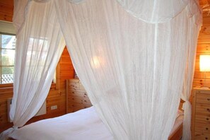A wooden room with a bed under a canopy. - Holiday home with 2 bedrooms (Ahrenshoop)
