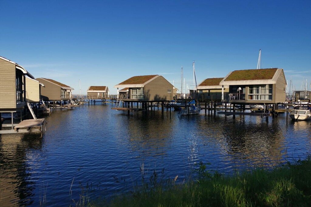 Ein Anwesen am Wasser mit mehreren Gebäuden, jedes mit einer flachen Decke und einem Steg, der ins Wasser ragt.