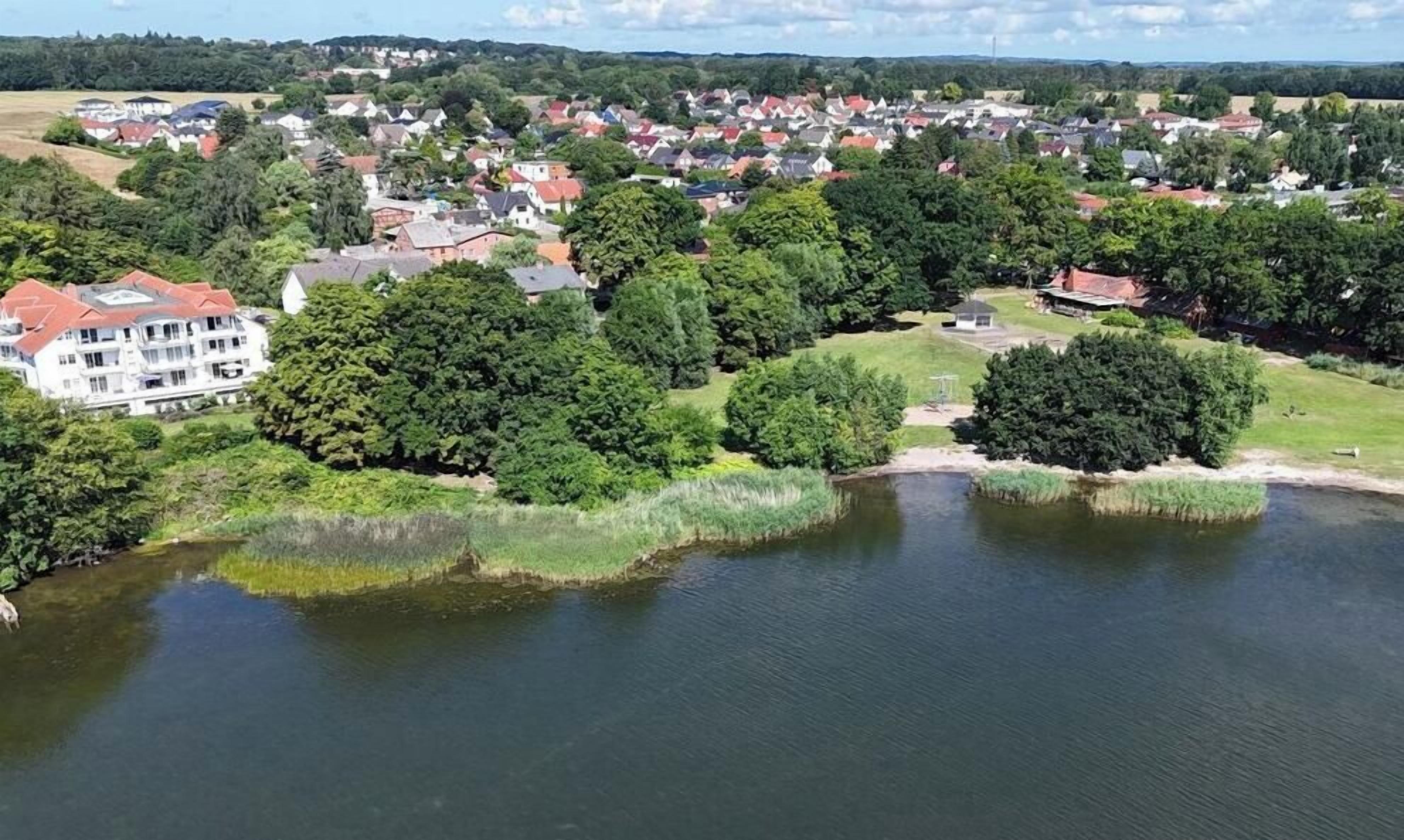 Een woonwijk met huizen, een groot gebouw en een waterpartij.