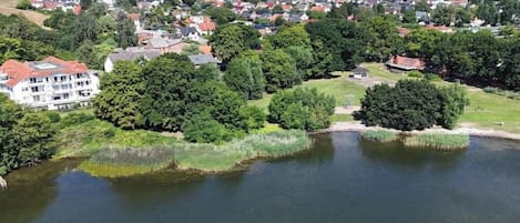 A residential area with houses, a large building, and a body of water.