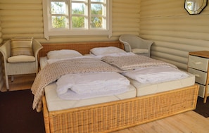 A room with a bed, a chair, a nightstand, and a window.