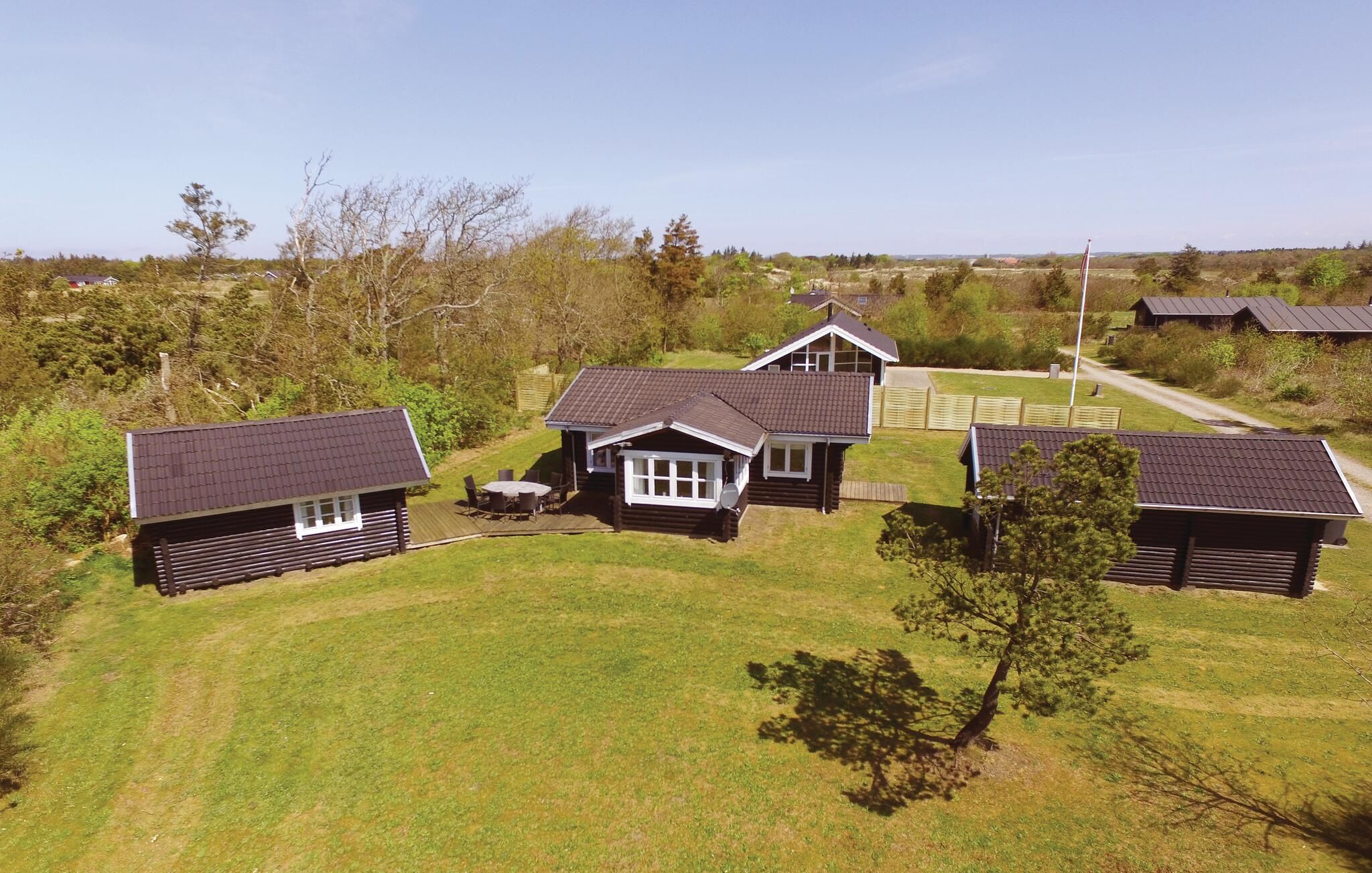 A cluster of cabins with a grassy yard and a clear sky.