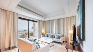 Een moderne hotelkamer met een bank, een salontafel, een televisie en een balkon met uitzicht.
