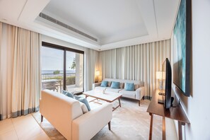 Et moderne hotelværelse med sofa, sofabord, TV og en balkon med udsigt.