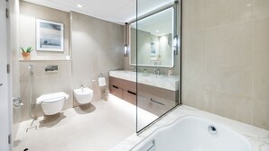 Een moderne badkamer met een douchecabine, een bad, een toilet en een wastafel.