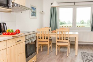 Eine Küche mit Holzsäulen, einem Herd und einem Esstisch mit Stühlen.