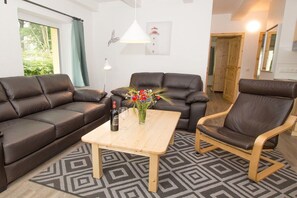 A living room with two sofas, a wooden coffee table, and a chair. - Terraced house - 2 bedrooms - 75 sqm (Ostseebad Rerik)
