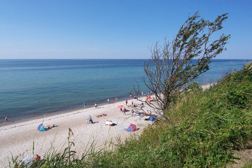 A beach with people, tents, and a clear sky.