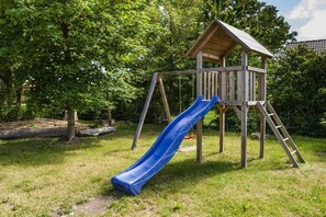 A wooden play structure with a slide and a ladder. - Terraced house, 60 sqm, 2 bedrooms (Rerik)