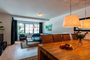 Un salon moderne avec une table à manger, un canapé et un téléviseur.