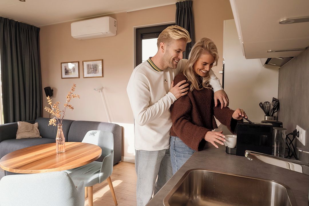 A modern kitchen with a built-in oven, a sink, and a coffee machine.