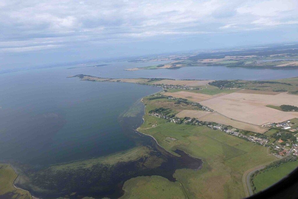 An aerial view of a coastal area with a mix of water bodies and agricultural fields.