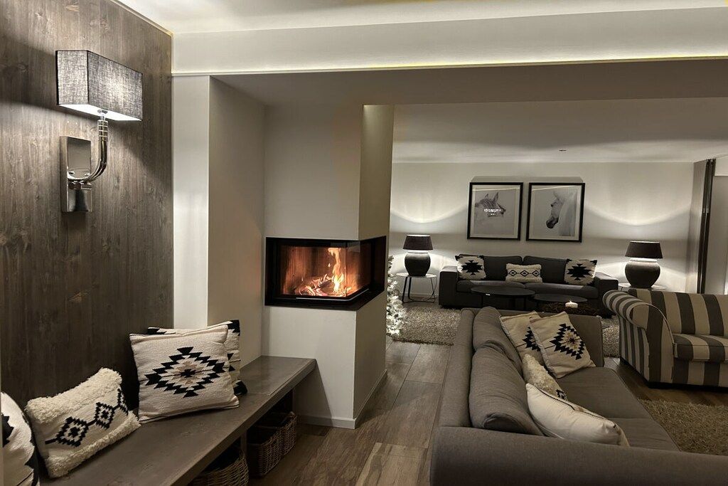 Una sala de estar moderna con chimenea, sofás y una mesa de centro.