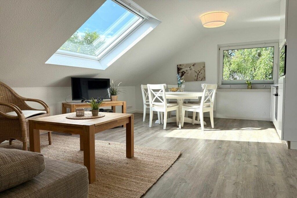 Ein Zimmer mit Oberlicht, Essbereich und Fernseher.