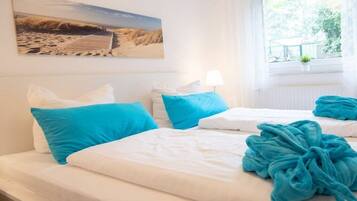 A hotel room with a bed, pillows, a window with a view, and a painting on the wall.