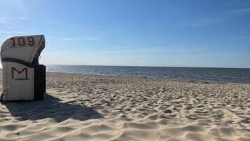 A beach with a white structure marked with the number 109 and the letter M.