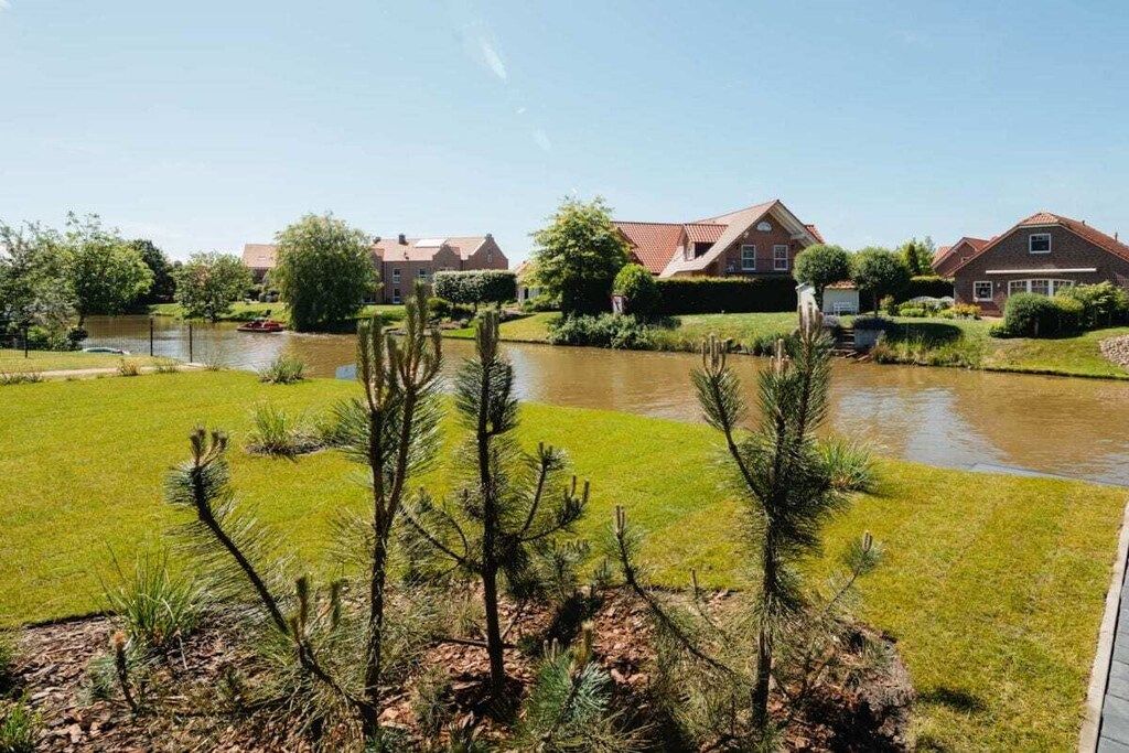A residential area with houses, a pond, and a grassy lawn.