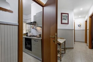 A kitchen with a stove, sink, and modern cabinetry. - Holiday Home 'San Pietro House' with Balcony, Wi-Fi and Air Conditioning (Roma)