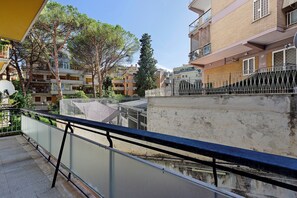 A balcony with a metal railing overlooking a residential area with multi-story buildings and trees. - Holiday Home 'San Pietro House' with Balcony, Wi-Fi and Air Conditioning (Roma)