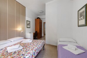 A hotel room with two beds, a wooden panel wall, a desk, and a chair. - Holiday Home 'San Pietro House' with Balcony, Wi-Fi and Air Conditioning (Roma)