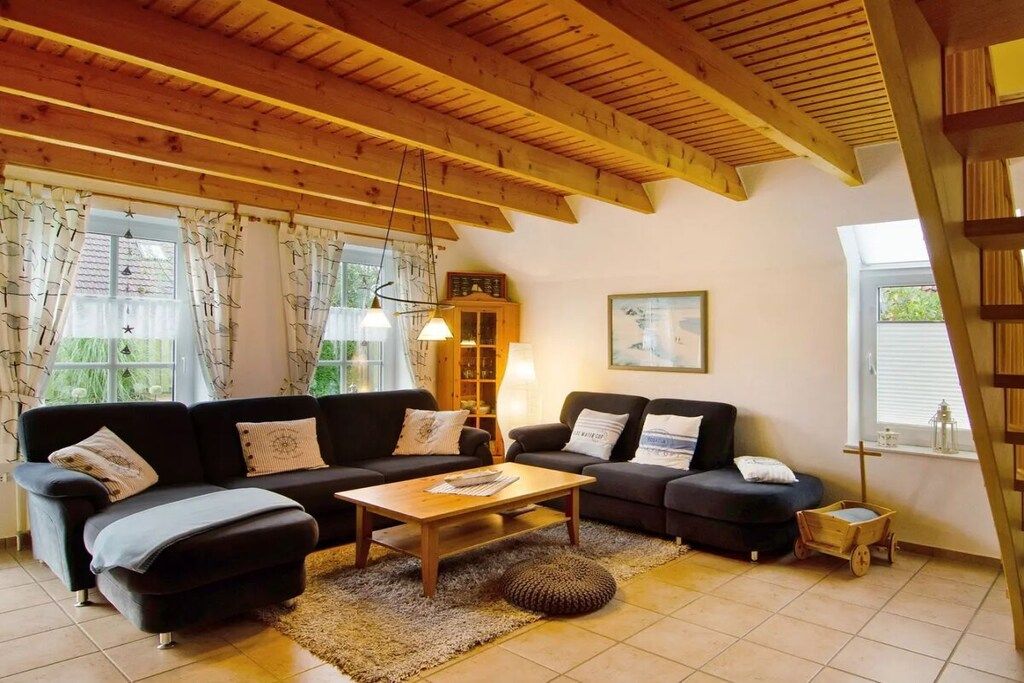 Ein gemütliches Wohnzimmer mit Holzboden, zwei Sofas, einem Couchtisch und einem kleinen Beistelltisch.