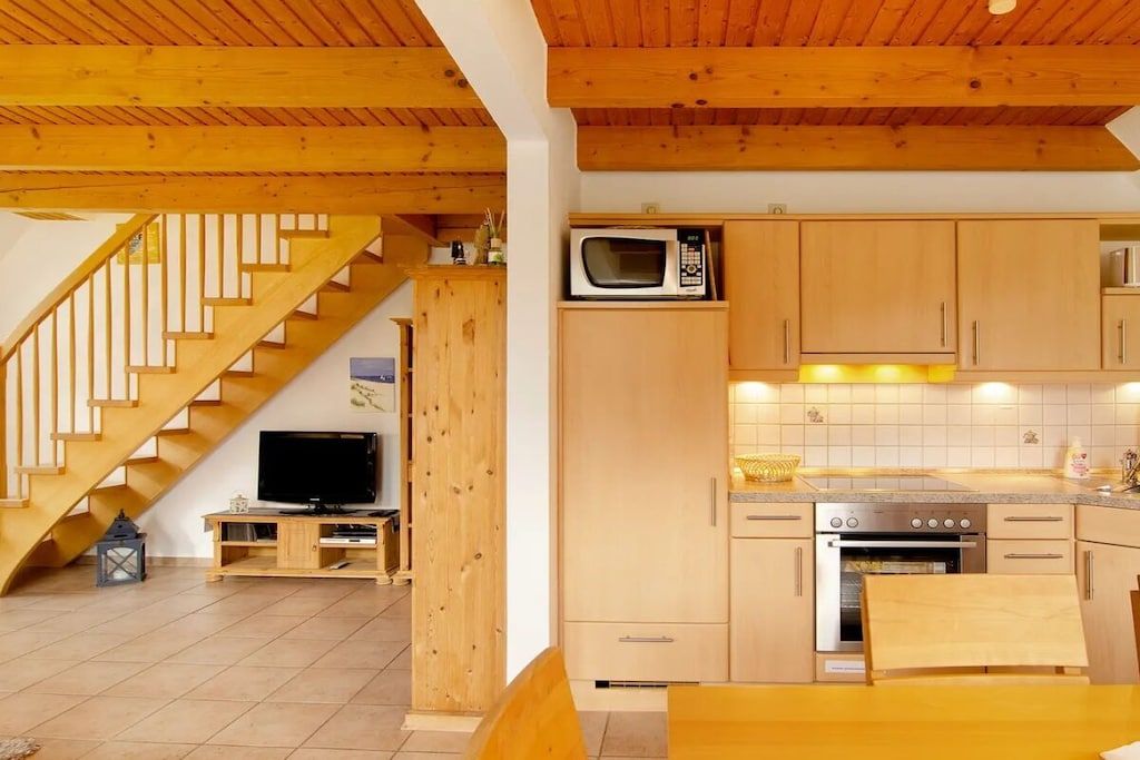 A kitchen with wooden cabinets, a microwave, and a stove.