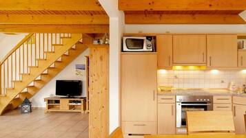 A kitchen with wooden cabinets, a microwave, and a stove.