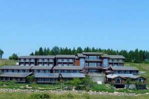 A multi-story building with a modern architectural style, featuring large windows and a flat roof.