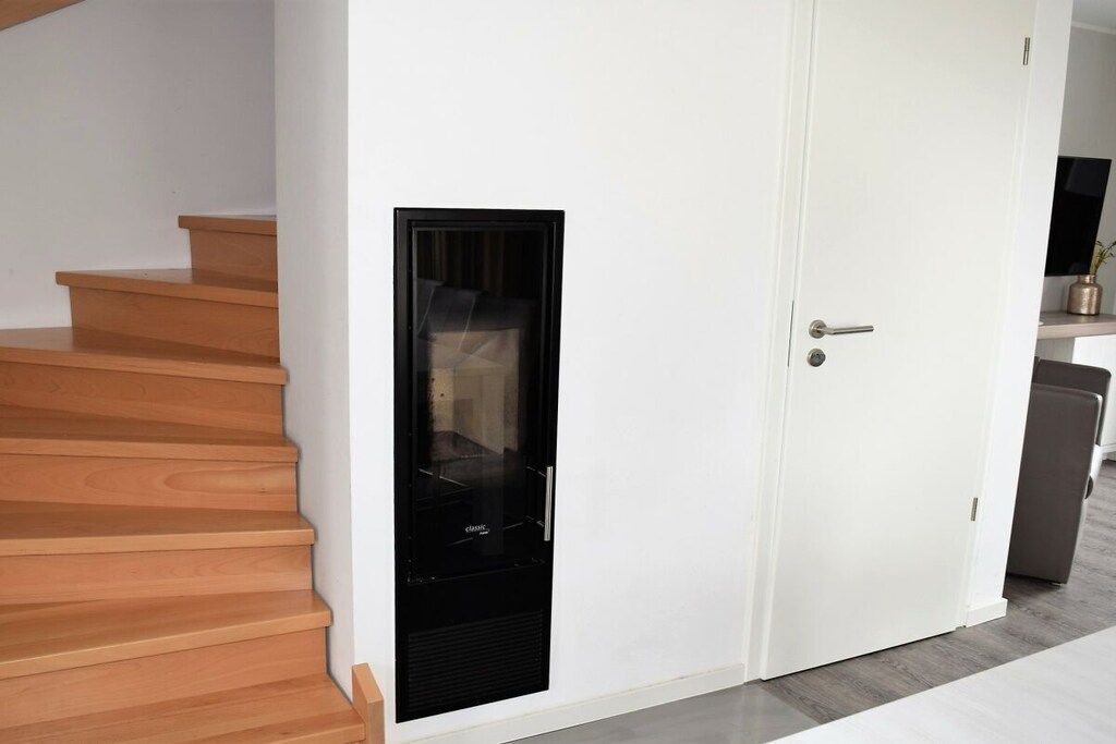 A staircase leading to a white door with a black intercom system.