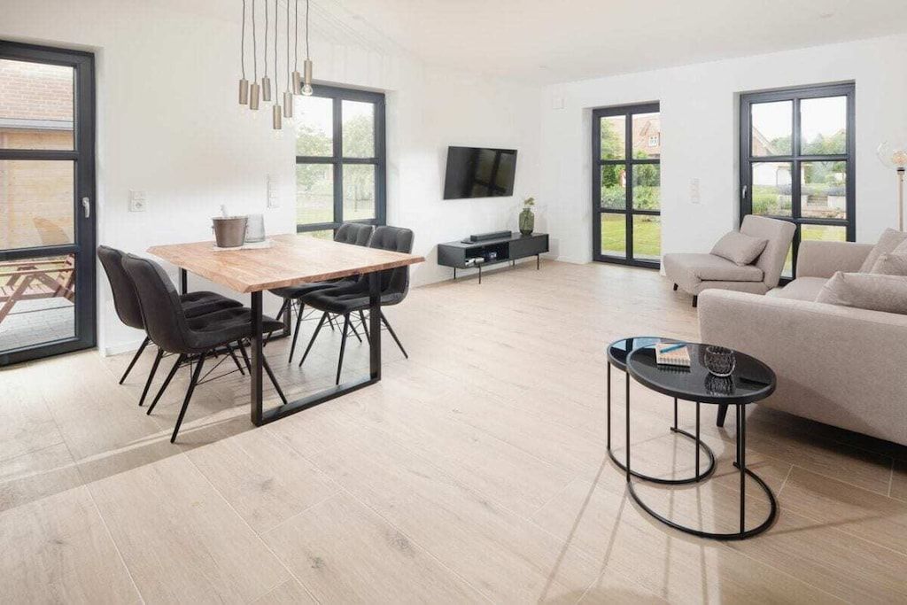 A modern living space with a dining area, sofa, and TV.