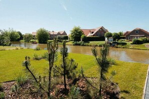 Een woonwijk met huizen, een vijver en groen.