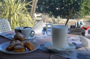 A table with a plate of pastries, a cup of coffee, a glass of milk, and a box of Moka pots. - Londra (Cervia)