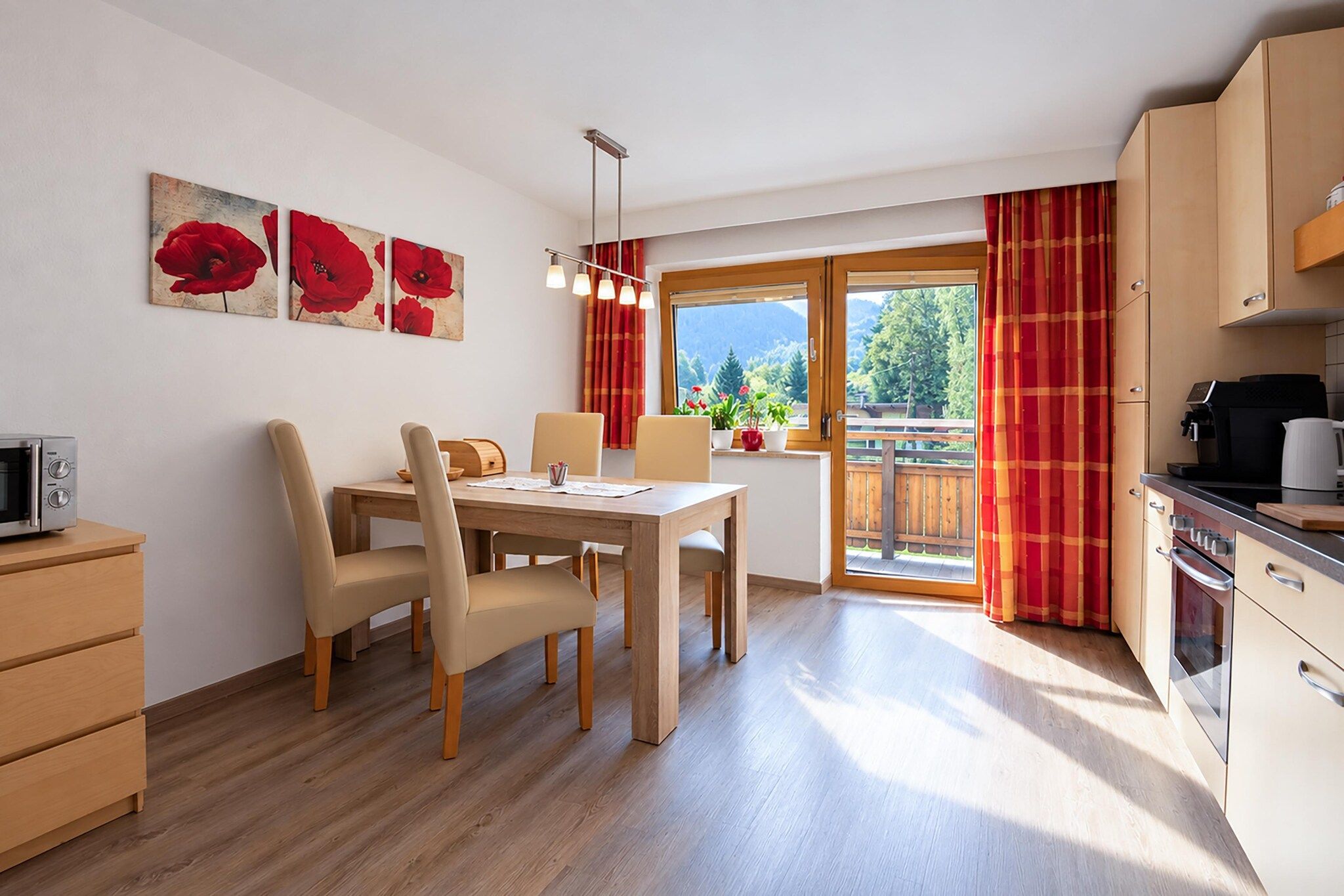 Une cuisine moderne avec des meubles en bois, un coin repas comprenant une table et des chaises, et une fenêtre avec des rideaux.