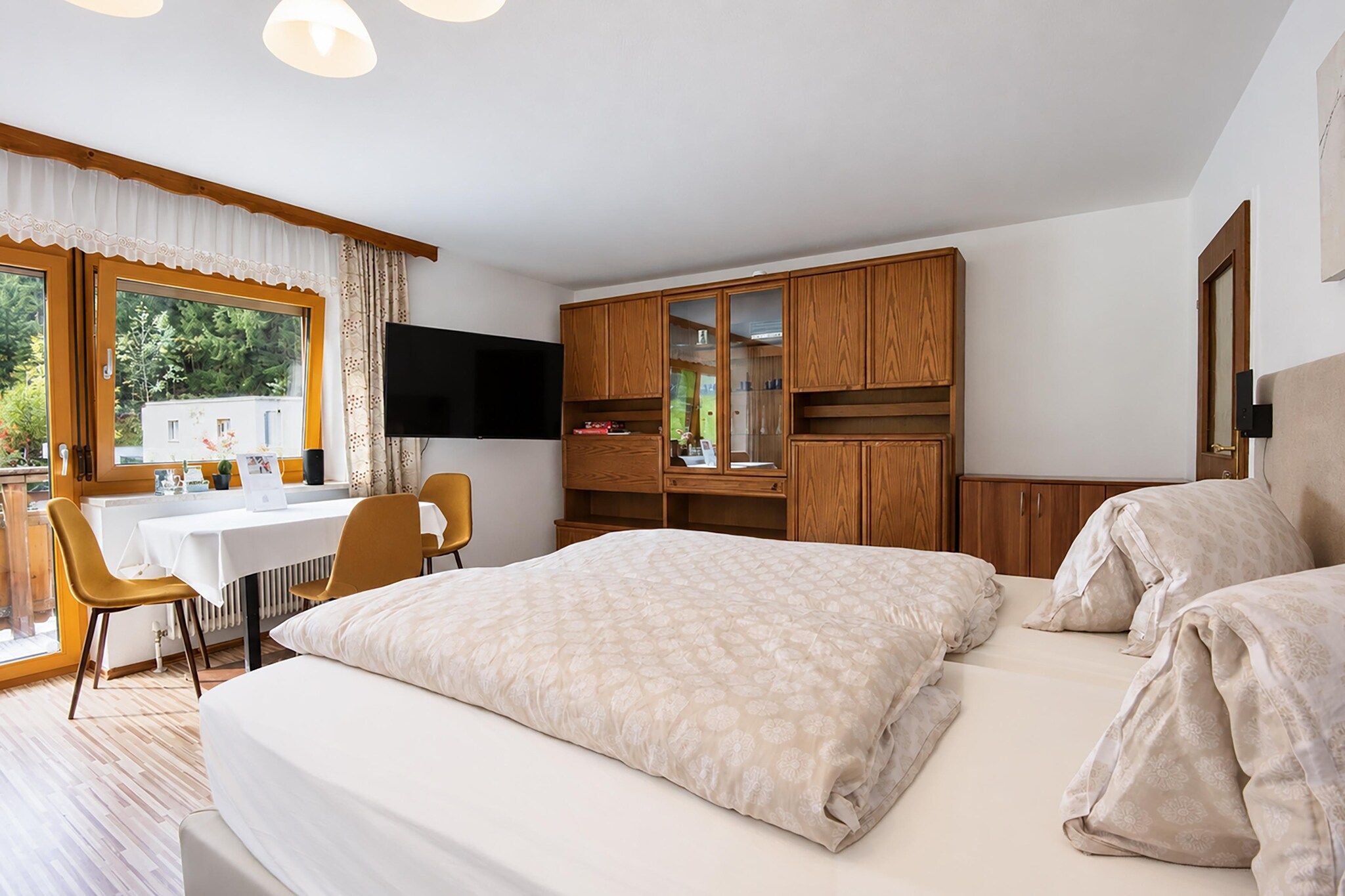 Ett hotellrum med en säng, ett skrivbord, en stol, en tv och en garderob.