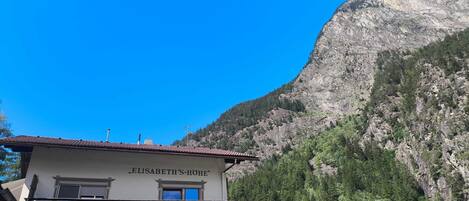 Un edifici anomenat 'ELISABETH'S-HÖHE' amb un balcó, amb les muntanyes al fons.