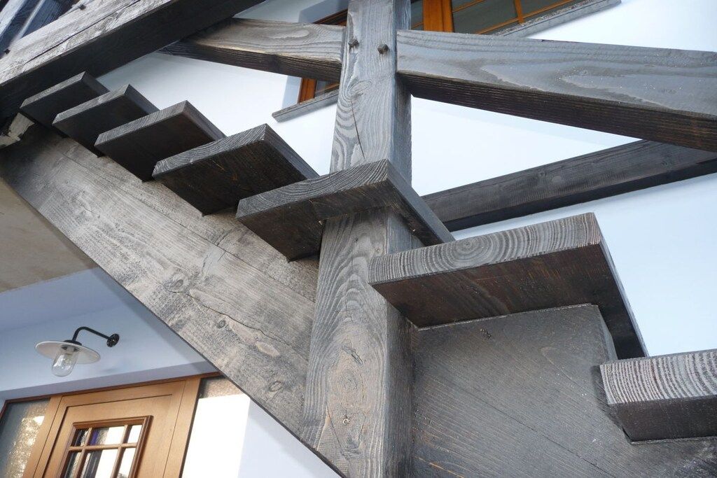 A wooden staircase with a modern design, leading to an upper floor.