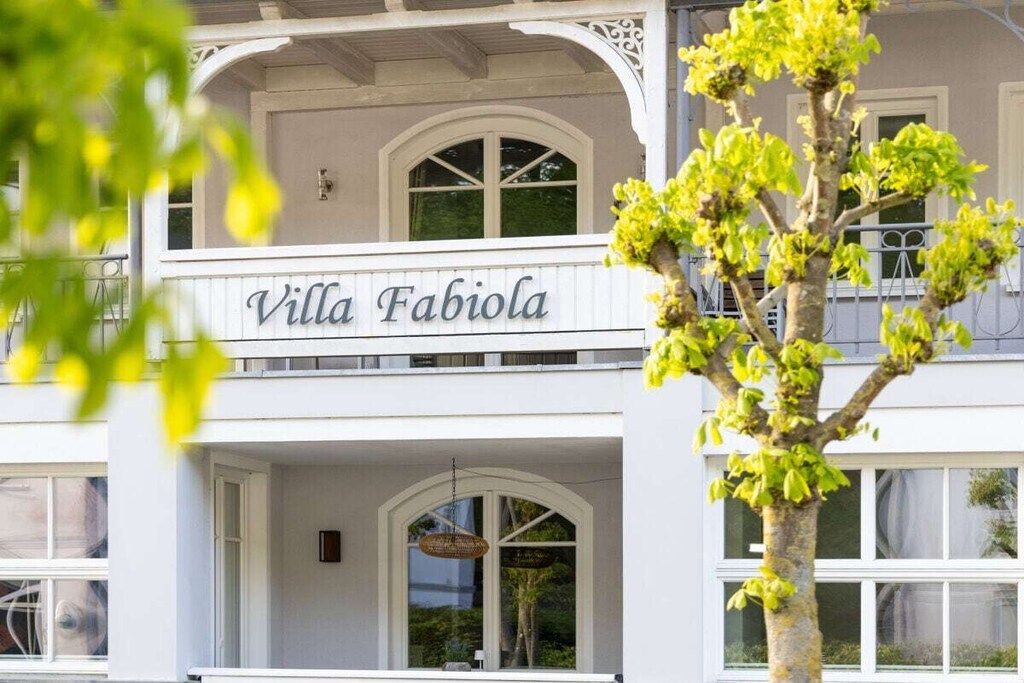Ein zweistöckiges Gebäude, auf dessen Fassade der Name 'Villa Fabiola' gut sichtbar angebracht ist.