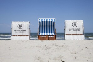 Three beach chairs with 'Beach Cloud Villa Augustine' branding, positioned on a sandy beach with the ocean in the background. - Baltic Cloud at Villa Augustine (Ostseebad Binz)