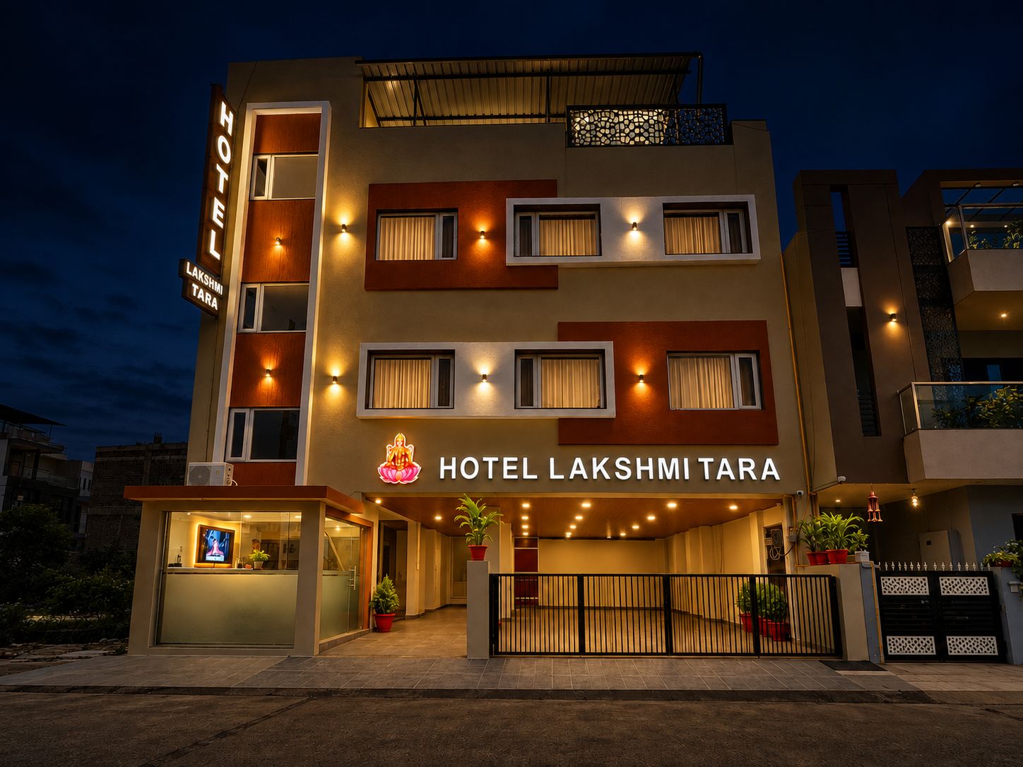 Un hotel de varios pisos con un cartel llamativo que dice 'HOTEL LAKSHMI TARA'.