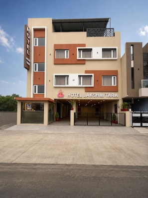 A multi-story hotel with a modern facade, a visible entrance, and a sign reading 'HOTEL LAKSHMI TARA'. - Hotel Lakshmi Tara (Ujjain)