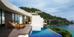 Una piscina infinita moderna con vistas al mar y una ladera.