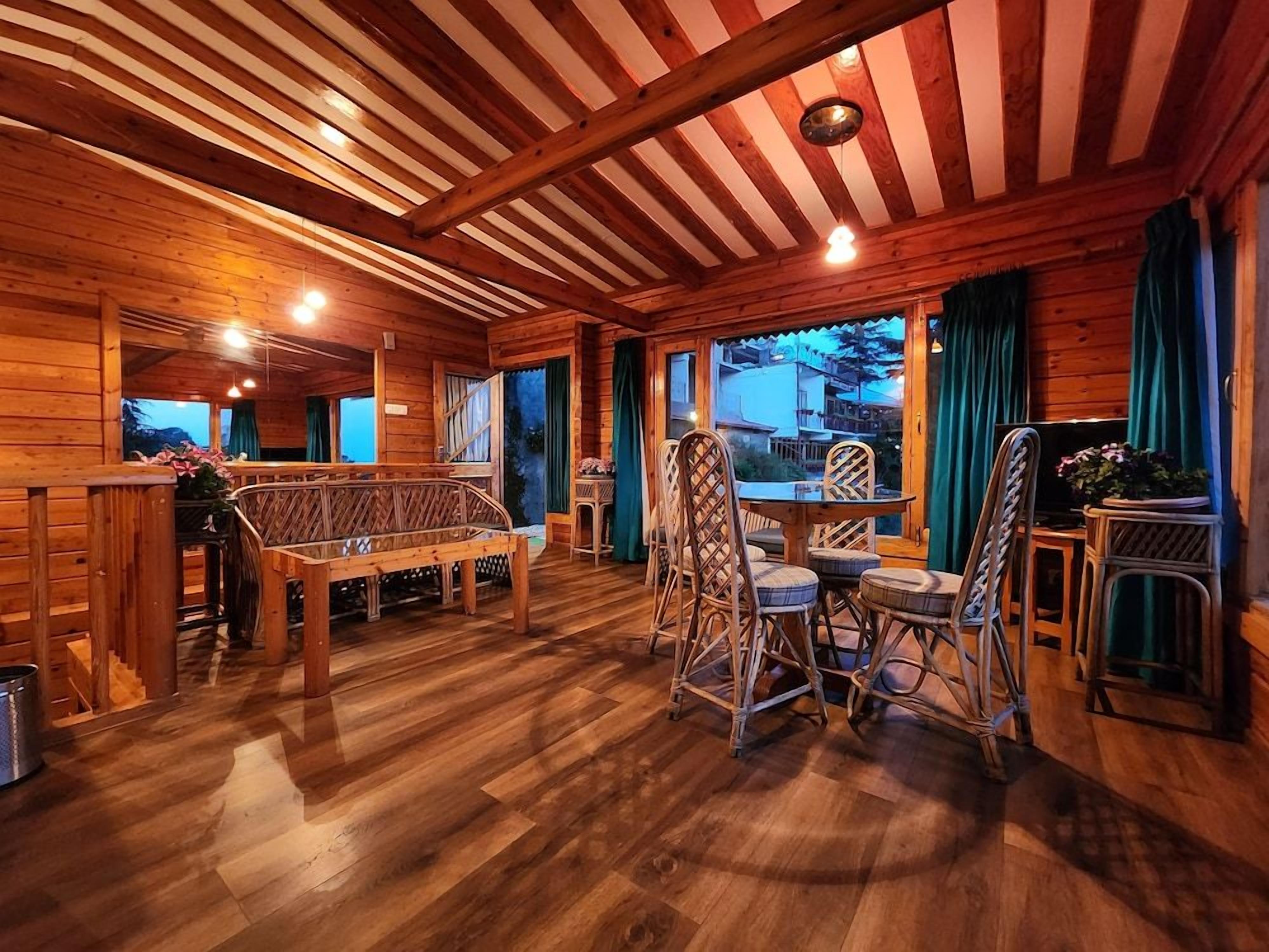 A wooden interior with a dining area, a bench, and wicker chairs.