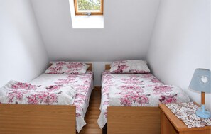 A bedroom with two single beds, a small window, a bedside table with a lamp, and a wall-mounted shelf. - 2 bedroom awesome home in Oslonka (Oslonka)