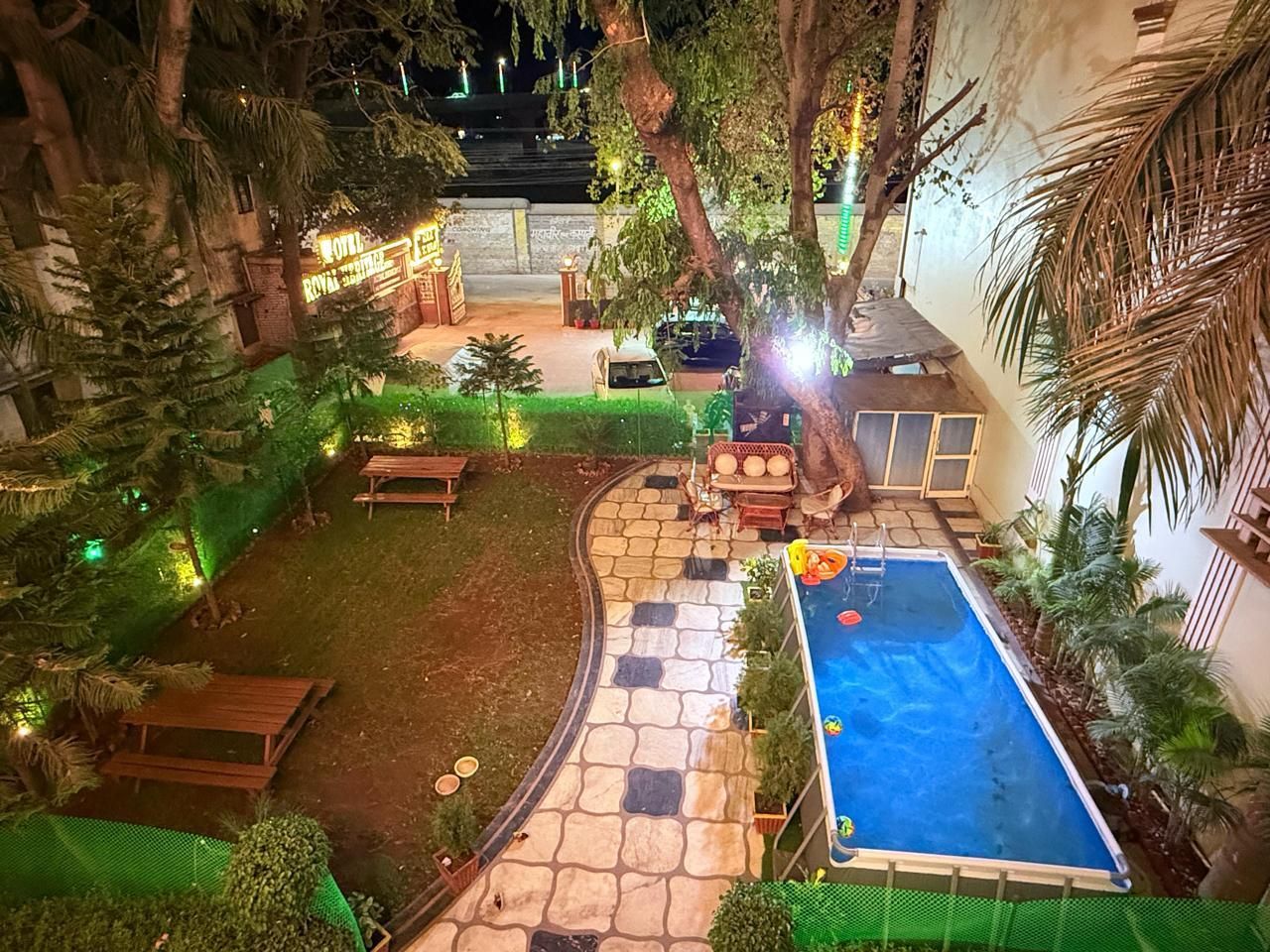 Ein Poolbereich mit Steinweg, Sitzgelegenheiten und Pool.