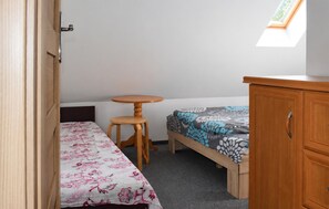 A small room with a bed, a wooden cabinet, and a round wooden table. - 2 bedroom stunning home in Oslonka (Oslonka)