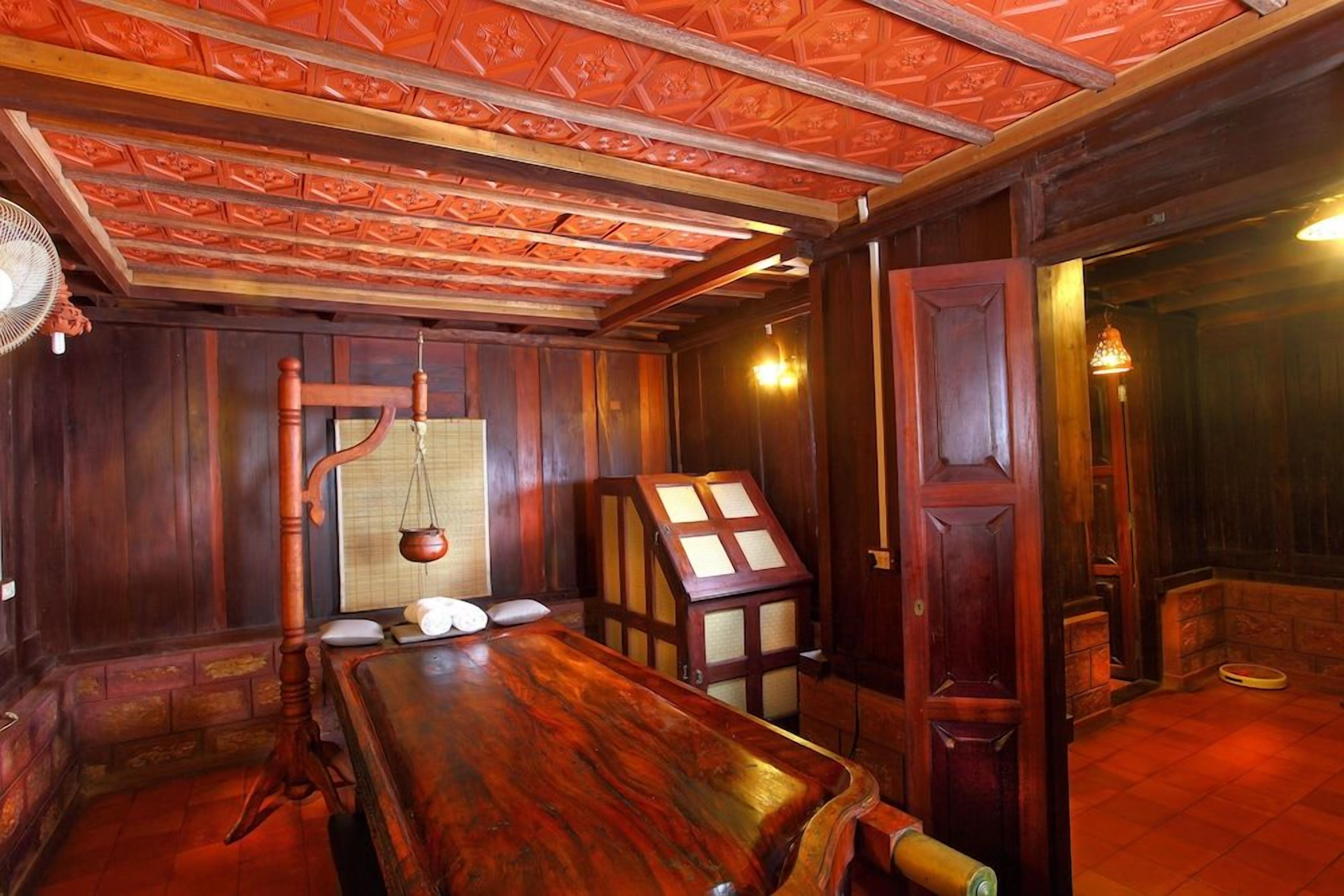 A room with a wooden table, a traditional scale, and a cabinet with glass doors.
