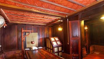 A room with a wooden table, a traditional scale, and a cabinet with glass doors.