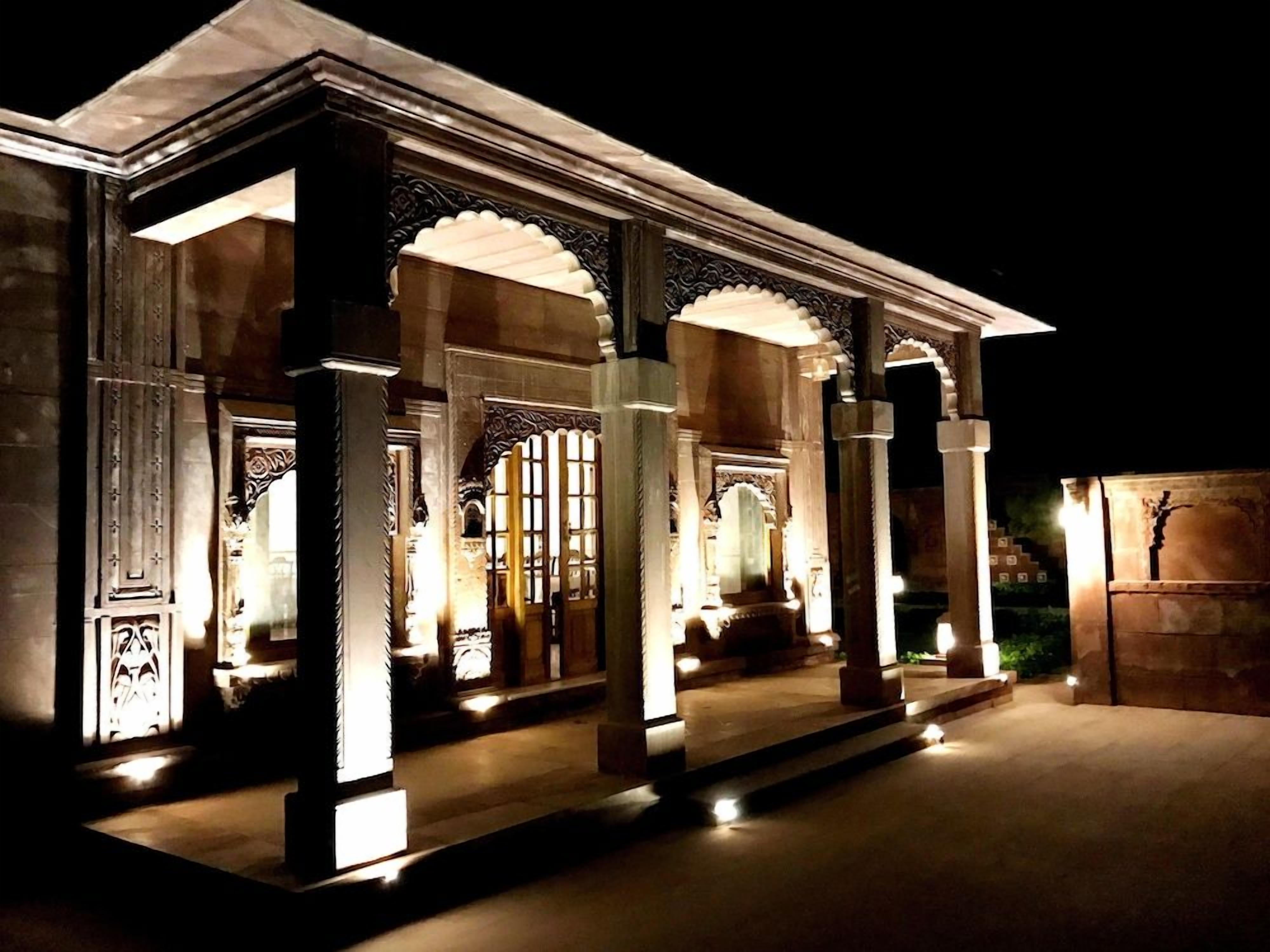 A building with ornate columns and arches, illuminated by artificial lighting.